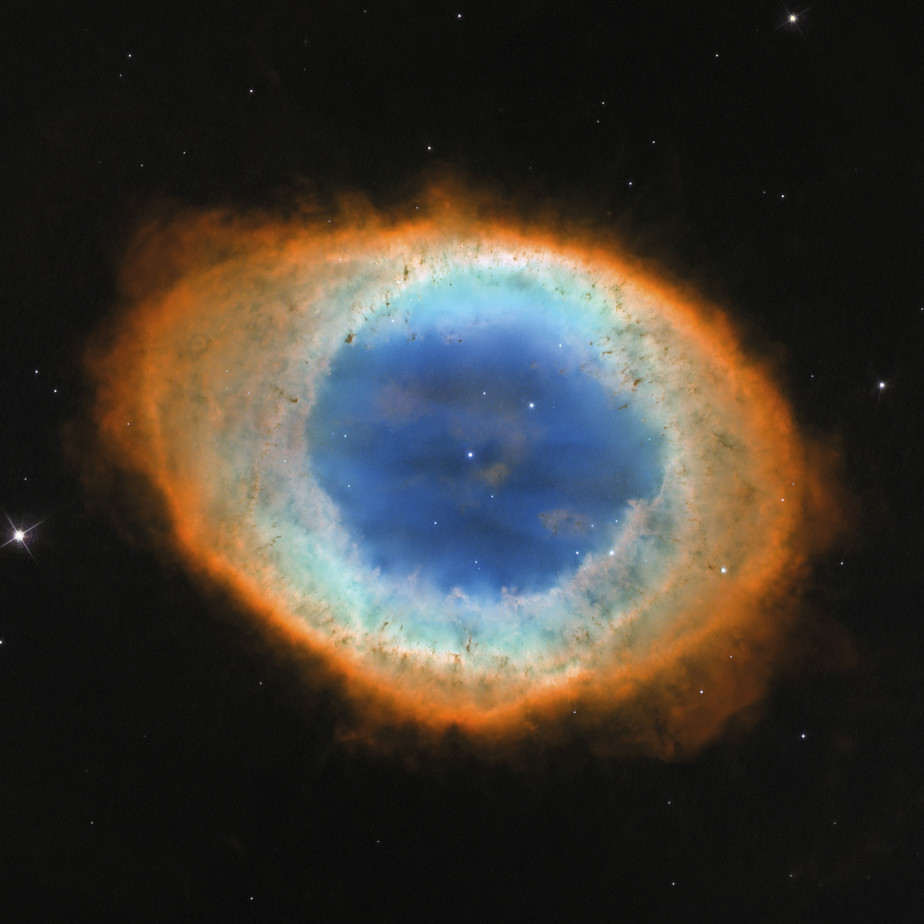 The colored image shows an eye-shaped nebula in the universe. The center is circular and blue, surrounded by an orange ring.